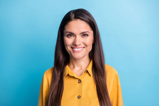 Photo portrait of smiling woman in casual shirt isolated on bright blue color background.