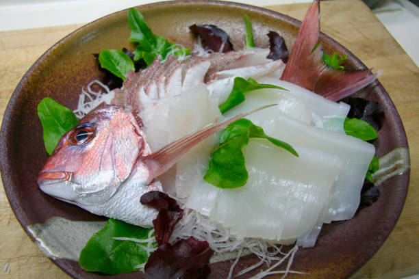 istock Squid and Red sea bream arranged in its original shape sashimi plate. 1406904674