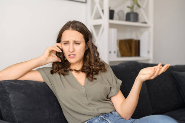 istock Annoyed woman talks over phone at home 1406904731