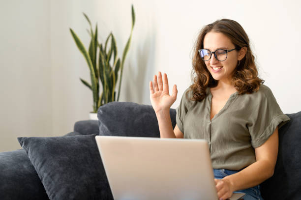 istock Attractive curly young woman using laptop for video call 1406904738