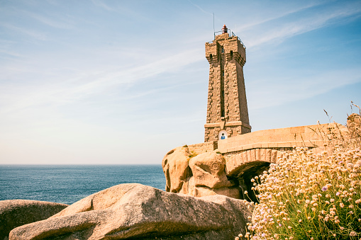 Ploumanach lighthouse or Phare de Men Ruz at the pink granite coast in Brittany, France during a beautiful summer day.