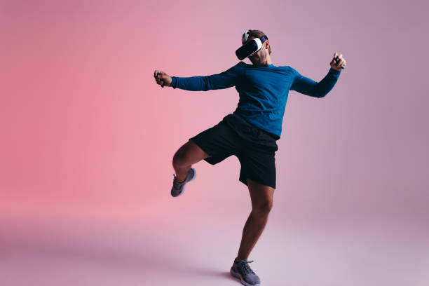 Sporty young man kicking a virtual ball in the metaverse stock photo