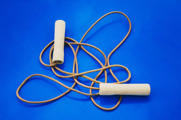 Jump rope on blue yoga mat. Wooden and leather jumping rope on blue yoga mat.