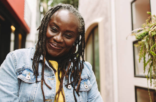 istock Woman with dreadlocks smiling at the camera happily 1406906059