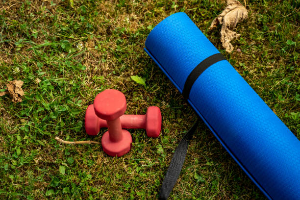 istock Blue exercise mat with weights on fresh green grass outdoors, closeup stock photo 1406906454