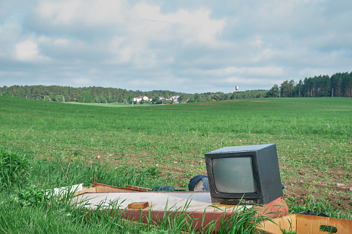 Old TV on the field near fores green grass summer