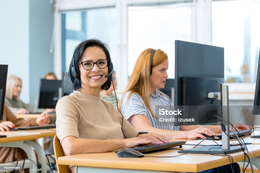 Smiling manager by female colleague Portrait of smiling manager by female colleague at desk in call center Day Stock Photo