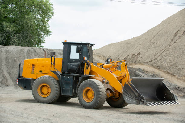 istock Sand loaders are shoveling rocks into dump trucks. 1406912432
