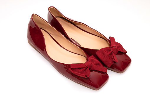 Female red patent leather flat ballerina shoes isolated on white