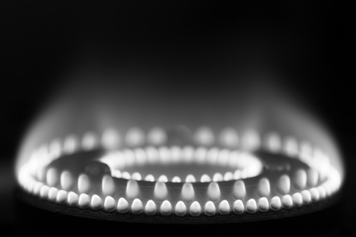 Flames on a domestic gas stove burner in monochrome