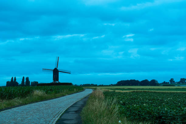 This beautiful Mountain mill is located in Wannegem-Lede Belgium, with the rise of the sun and  clouds.