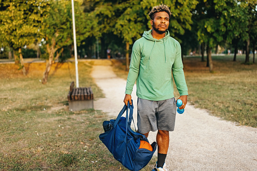 A young African American man is walking home after his morning training.
