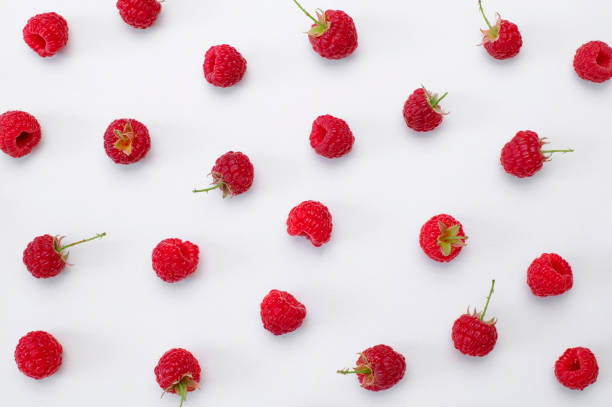 istock Ripe juicy fresh raspberries on white background flat lay top view. Raspberry pattern. Organic raspberries, healthy food, vitamins, summer berry fruit background. Raspberry harvest 1406918972
