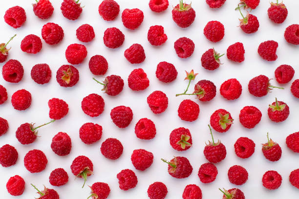 istock Ripe juicy fresh raspberries on white background flat lay top view. Raspberry pattern. Organic raspberries, healthy food, vitamins, summer berry fruit background. Raspberry harvest 1406918978