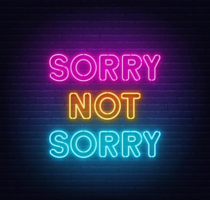 Sorry Not Sorry neon lettering on brick wall background .