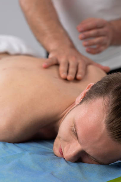 istock Professional back massage the therapist man doing to his client while the guy are laying down on the massage table 1406920868