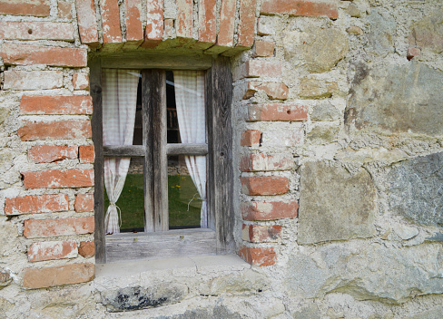 Aged wooden window with glazing and partially weathered in rustic homes