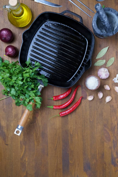 istock Black iron empty grill pan on wooden texture 1406922744