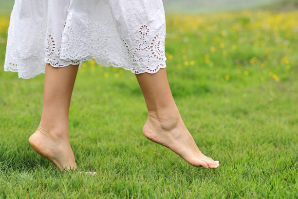 Woman bare feet walking on the grass in the mountain stock photo