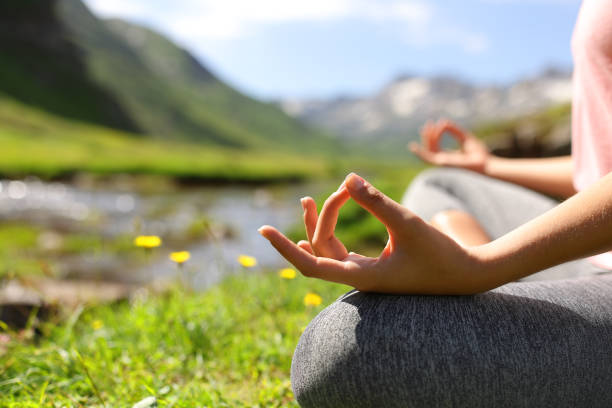 Close up of a woman hands doing yoga in nature stock photo