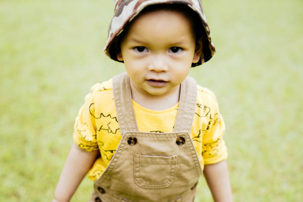 Baby boy playing and  running on lawn in spring