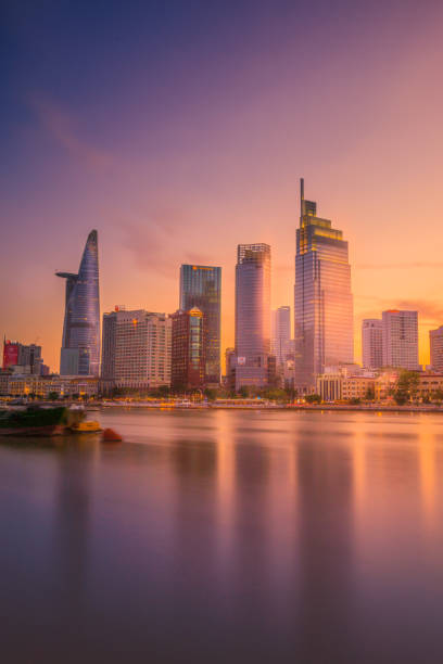 panorama miasta ho chi minh i rzeka sajgon o zachodzie słońca. niesamowity kolorowy widok na wieżowiec i inne nowoczesne budynki w centrum miasta. - ho chi minh zdjęcia i obrazy z banku zdjęć