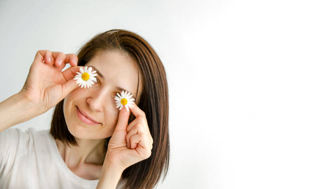 istock the girl is holding chamomile flowers in her hands. Selective focus 1406932111