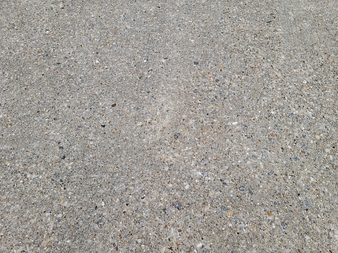 pebbles and rocks conglomerate in the grey cement on the ground