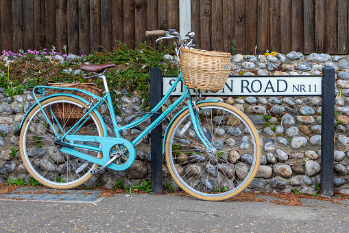A bicycle propped up against the street sign for Station Road in the village of Mundesley in Norfolk, UK.