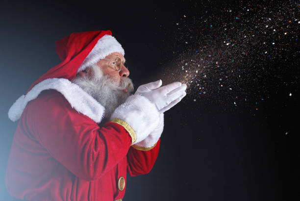 istock Christmastime traditions. Santa blowing snowflakes. 1406933084