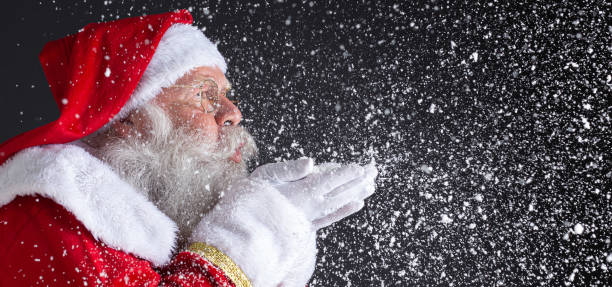 istock Christmastime traditions. Santa blowing snowflakes. 1406933089