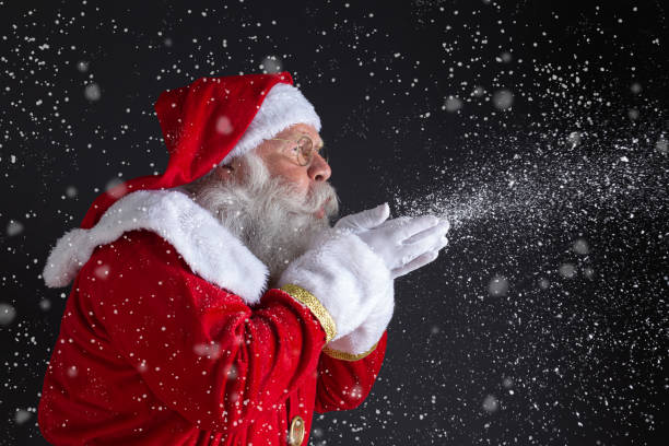 istock Christmastime traditions. Santa blowing snowflakes. 1406933672