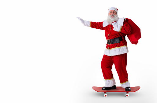 Santa riding a skateboard or longboard and holding a bag full of presents on white background.
