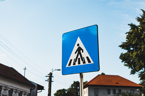 Pedestrian crossing blue rectangular road sign in an urban area