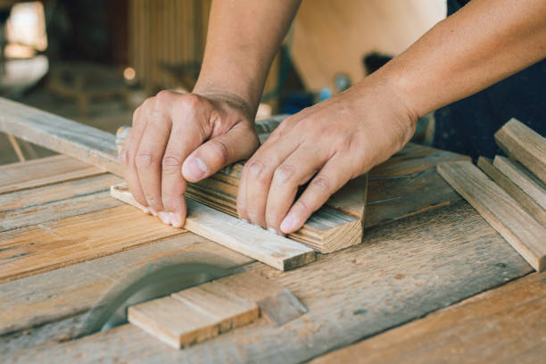 istock Asian carpenter is using a circular saw to cut wood to construct a storage box on a desk table at his factory. Working as your own boss at home concept 1406937418