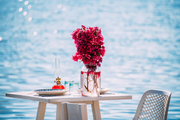 istock Dining Table Decorated With Flowers by the Sea 1406938290