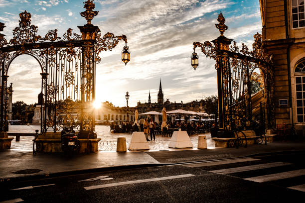 Nancy, France - June, 01 2022: Pedestrians and restaurant customers at sunset at a corner of Place Stanislas in the town of Nancy in the Lorraine district of France.