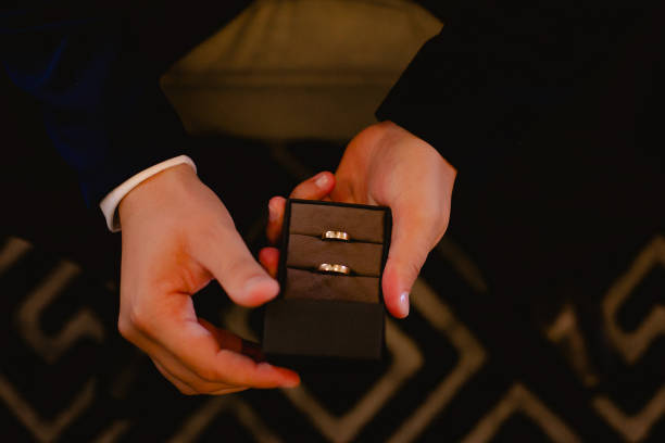istock Man holds two wedding rings in a jewelry box 1406941857