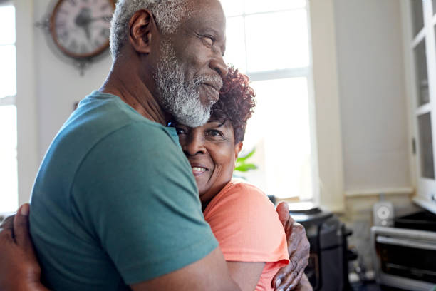 istock Black couple in their 70s embracing in home kitchen 1406942086