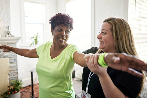 adulto mayor negro haciendo ejercicio con un trabajador de la salud - atención residencial fotografías e imágenes de stock