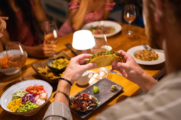 istock High angle view of unrecognizable man eating tacos, during dinner 1406943326