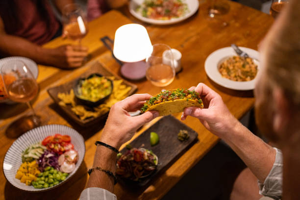 istock High angle view of unrecognizable man eating tacos, during dinner 1406943327