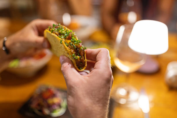 istock High angle view of unrecognizable man eating tacos, during dinner 1406944486