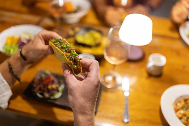 istock High angle view of unrecognizable man eating tacos, during dinner 1406944499