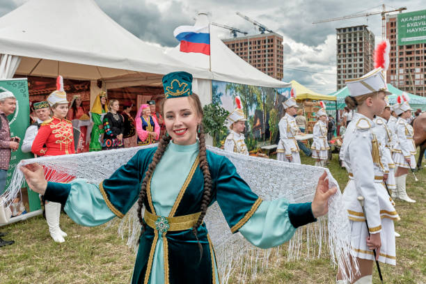 Asian woman in traditional festive Tatar clothes and jewelry, at Sabantuy national holiday. Yekaterinburg, Russia - June 25, 2022: Portrait of beautiful smiling Asian girl in traditional festive Tatar clothes and jewelry, with shawl, at Sabantuy folk festival. siberian flag stock pictures, royalty-free photos & images