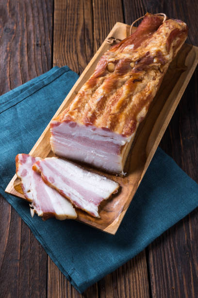 istock Pork belly on a wooden cutting board. Rustic old wooden table top. 1406948345
