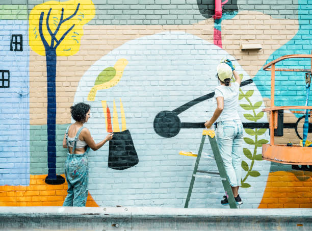 istock Two Female artists painting large wall mural 1406949535