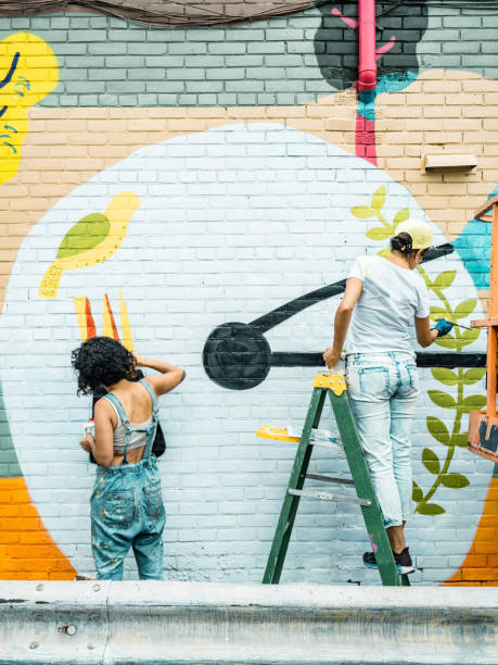 istock Two Female artists painting large wall mural 1406949601