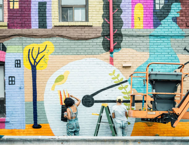 istock Two Female artists painting large wall mural 1406949633
