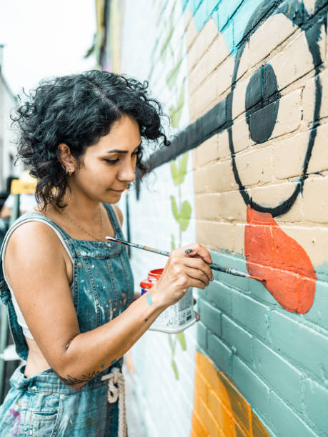 istock Female artist painting large wall mural 1406950314